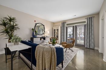 a living room with a blue couch and a table with chairs